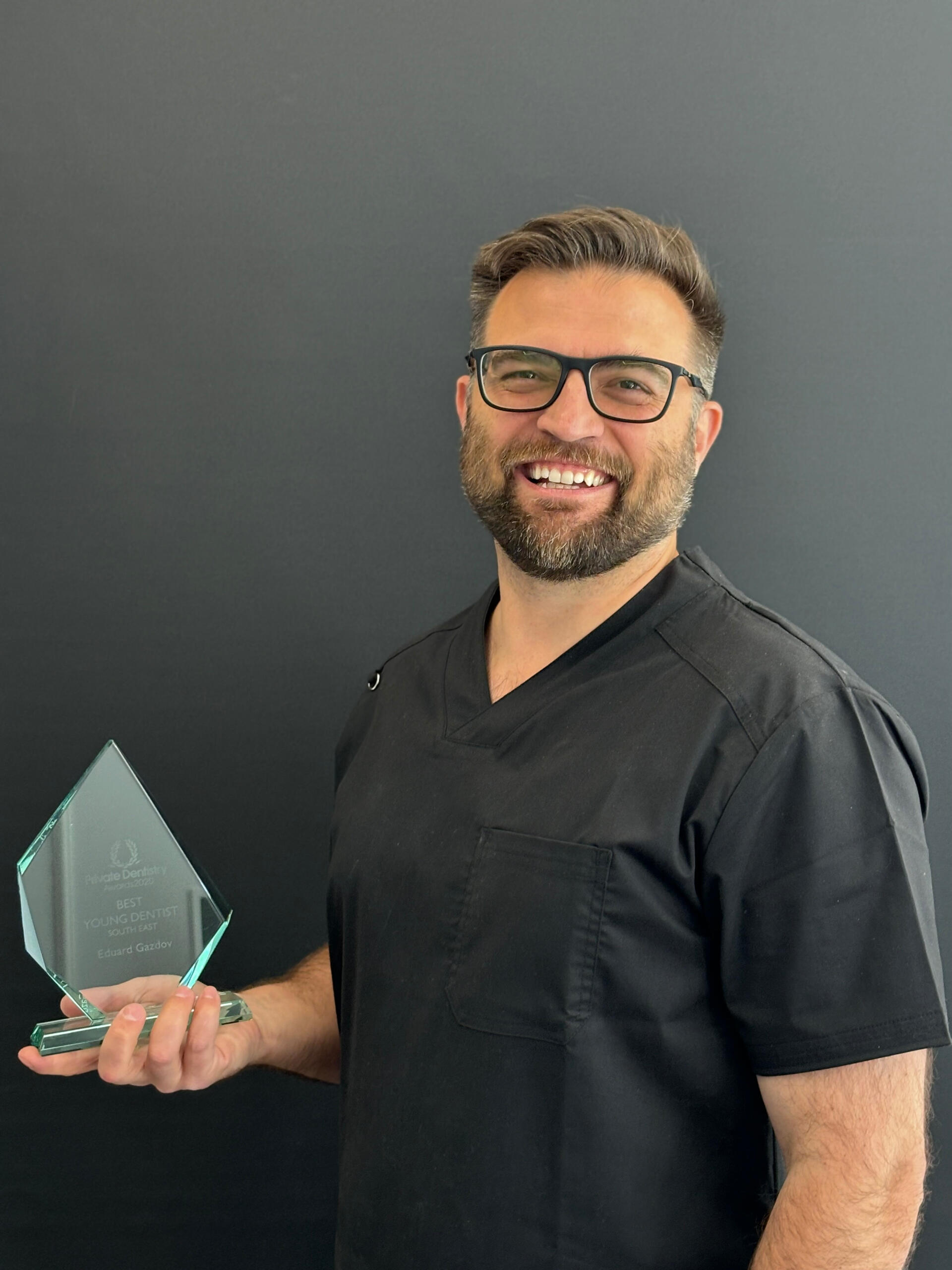 dr-eduard-gazdov-best-young-dentist-uk-award-2020 Dr Eduard Gazdov holding the Best Young Dentist UK 2020 (South East) award, recognised among top peers in British dentistry.